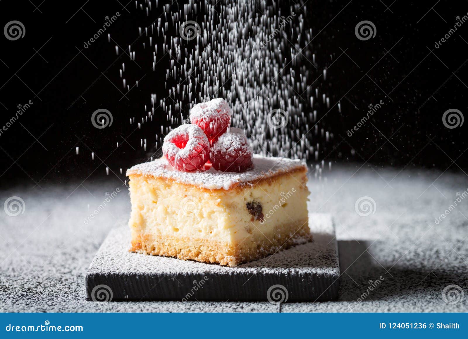 Falling Powdered Sugar on Cheesecake with Raspberries Stock Photo