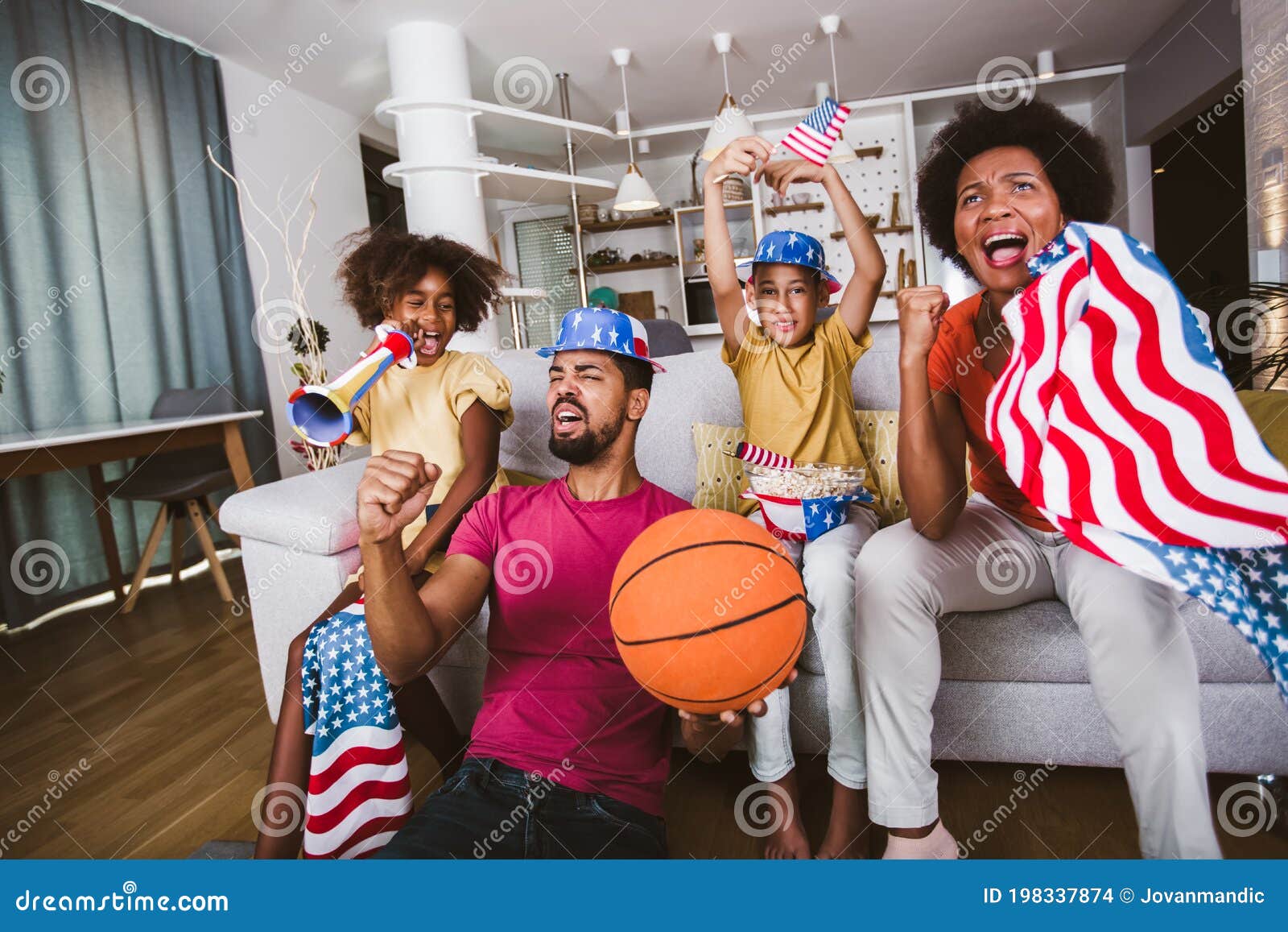 Família Afro-americana De Três Assistindo TV E Torcendo Jogos De Basquete  No Sofá Em Casa Foto de Stock - Imagem de feliz, basquete: 198337874