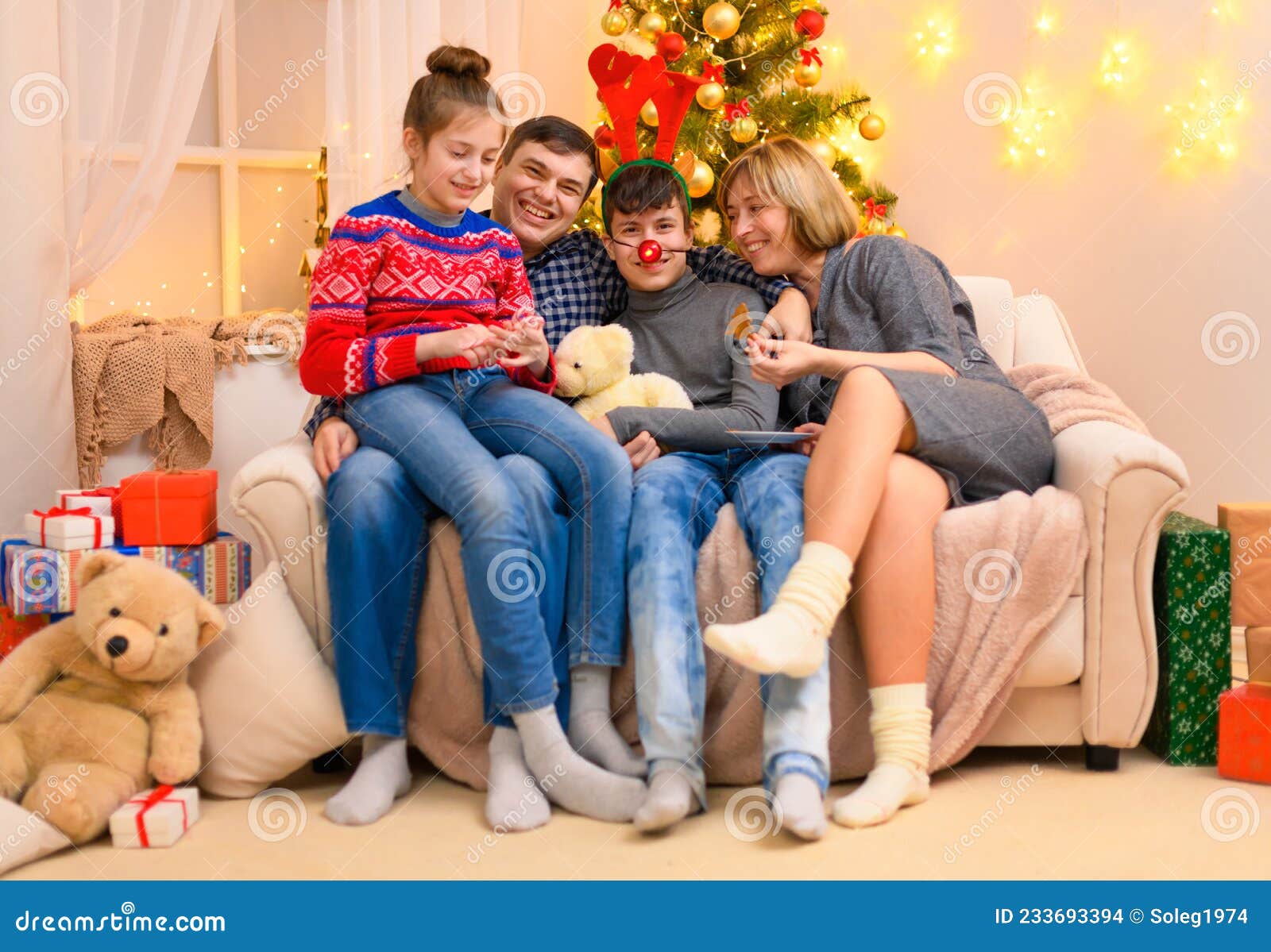 Família Conceito De Férias De Inverno Sentado Num Sofá Com Decoração De  Natal Ou De Ano Novo. Crianças E Pais. Feriado Foto de Stock - Imagem de  conversa, chifre: 233693394