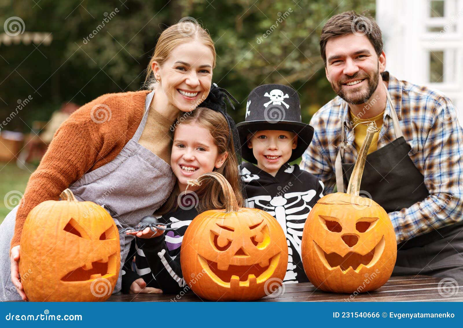 Família Jovem E Feliz, a Fantasia De Halloween Esculpindo Abóboras Juntas  No Quintal Foto de Stock - Imagem de junto, feliz: 231540666