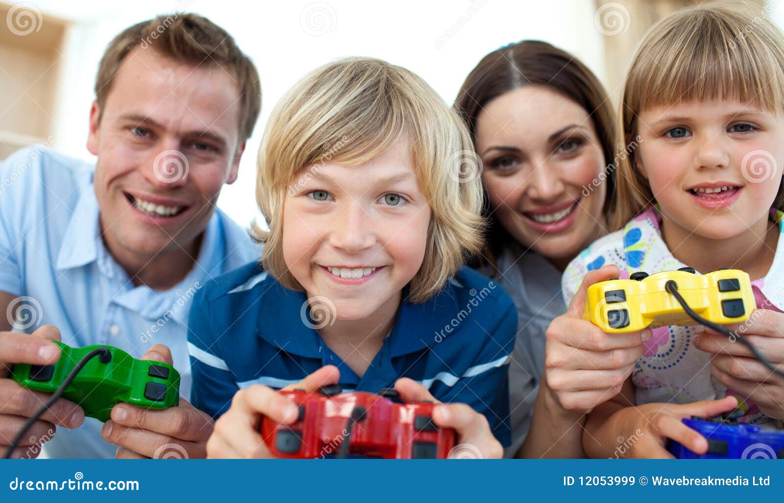 Famiglia sorridente che gioca insieme i video giochi sul sofà