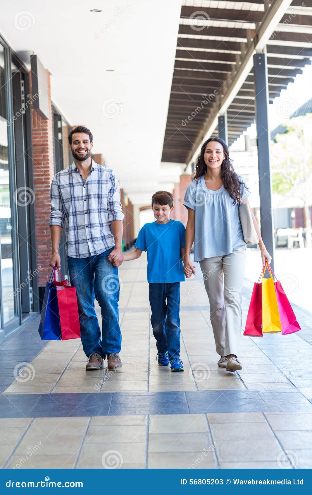 Familia feliz con los panieres en la alameda