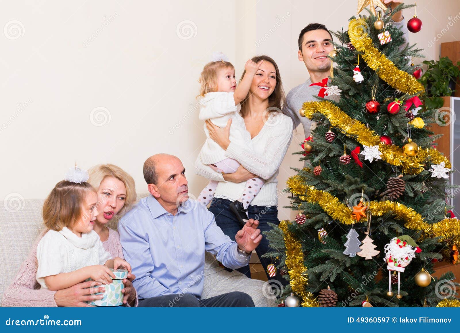 Familia que adorna el árbol de abeto. Familia larga con los niños magníficos que adornan el árbol de abeto