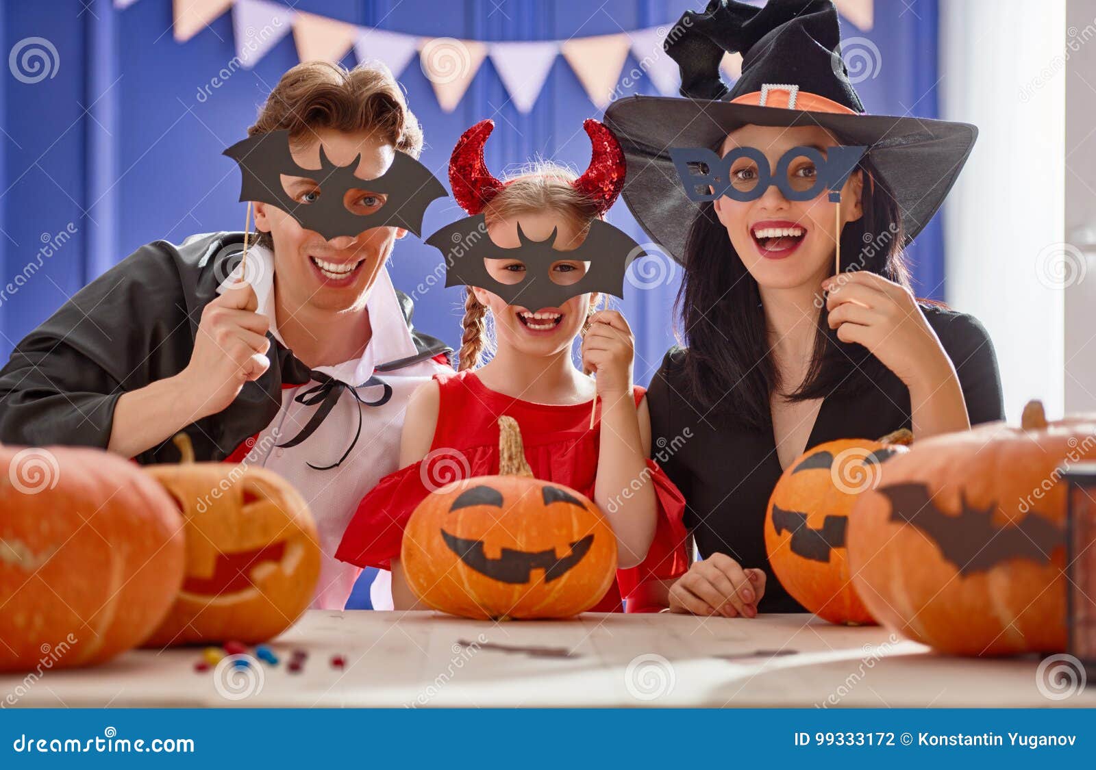 Familie die voor Halloween voorbereidingen treft. Moeder, vader en hun dochter die pret hebben thuis Gelukkige familie die voor Halloween voorbereidingen treffen Mensen die Carnaval-kostuums dragen