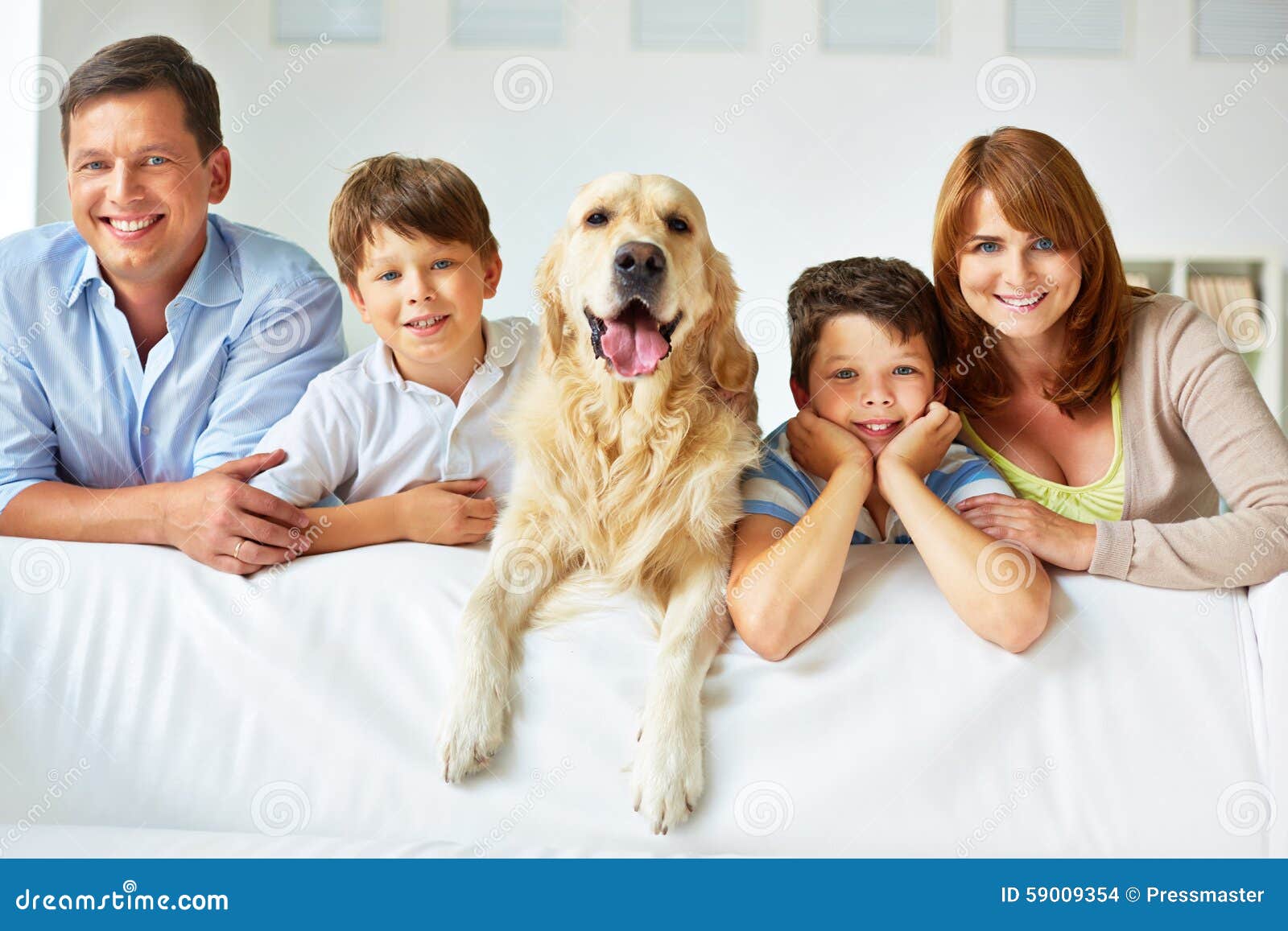 Familie op bank. Glimlachende familie van vier met een hond