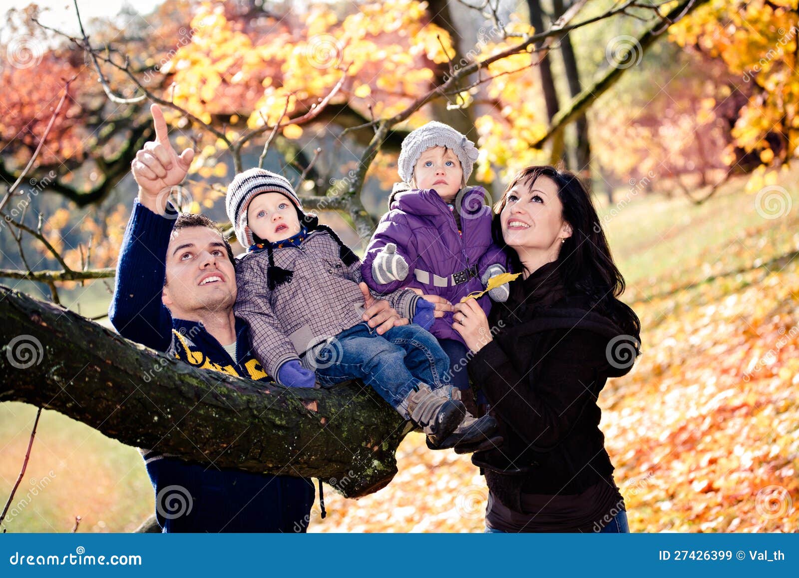 Stående av en ung familj i höstparken