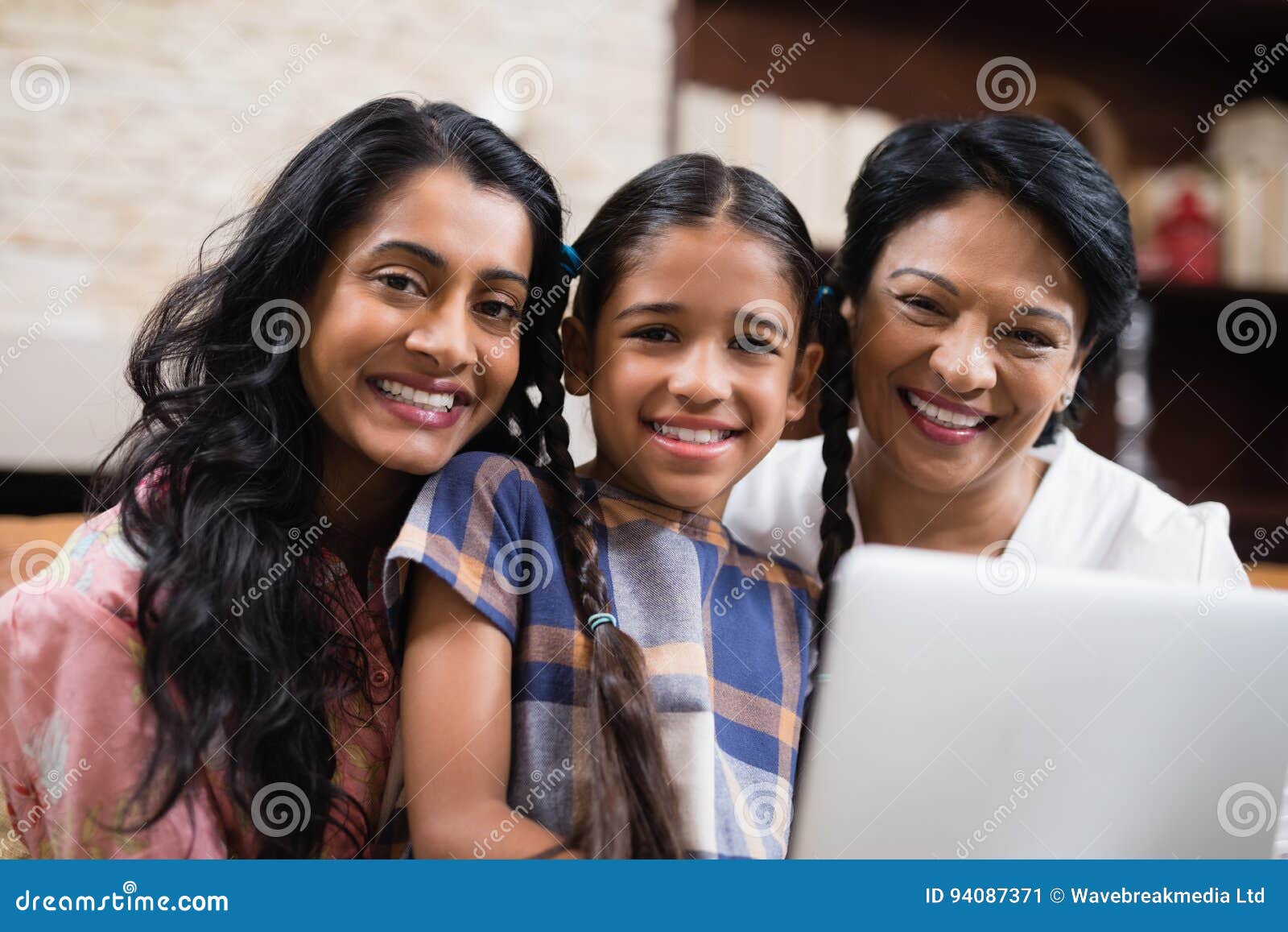 Famille sur plusieurs générations de sourire de portrait à la maison