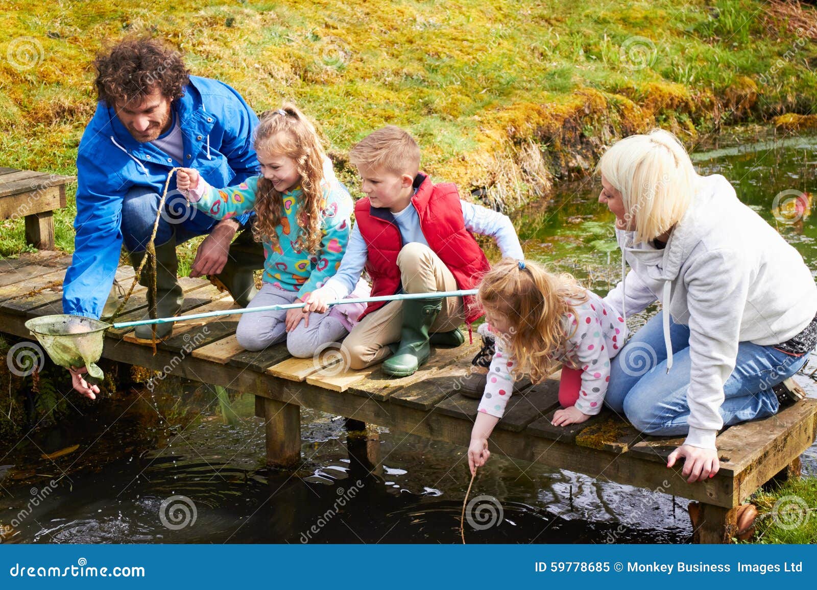 Family on Bridge Fishing in Pond with Net Stock Image Image of father