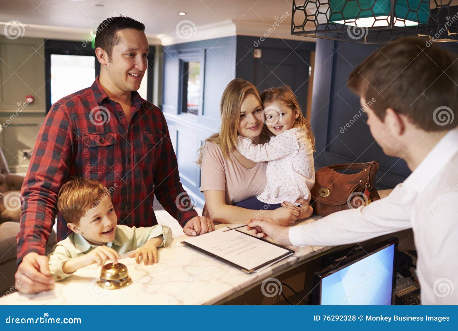 family checking in at hotel reception desk