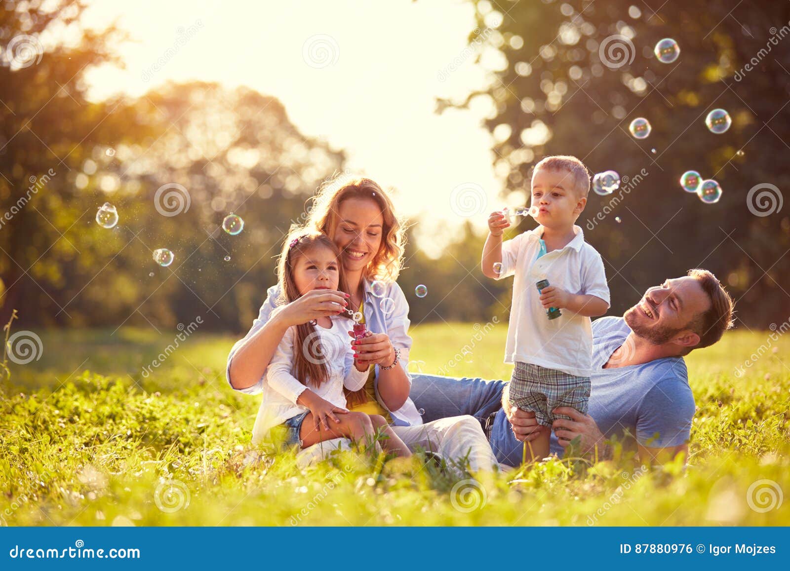 family with children blow soap bubbles