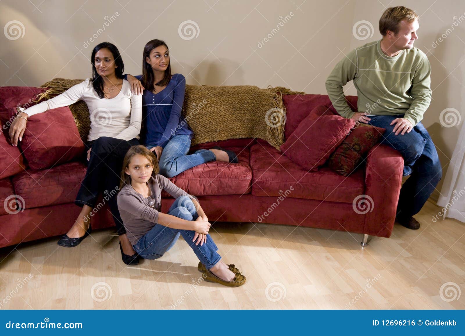 family on couch with father sitting apart