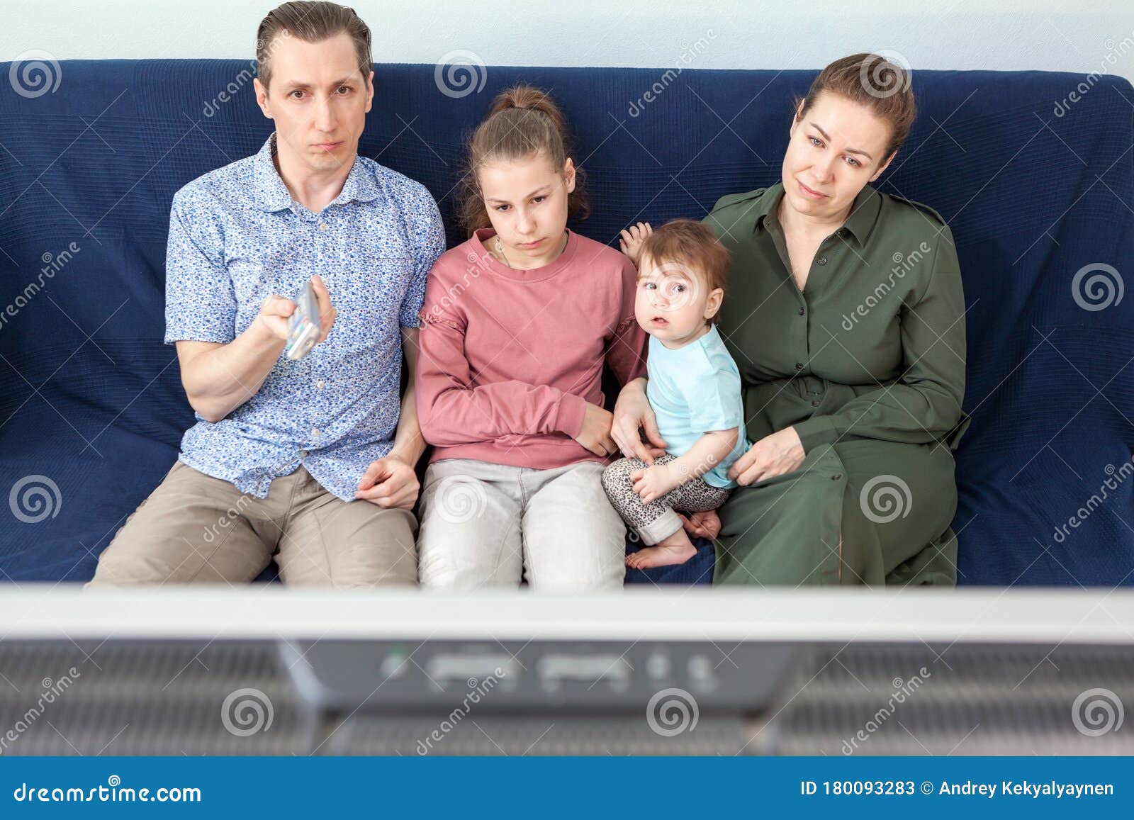 Family With Dad Mom Teen Daughter And Infant Child Watching Tvset