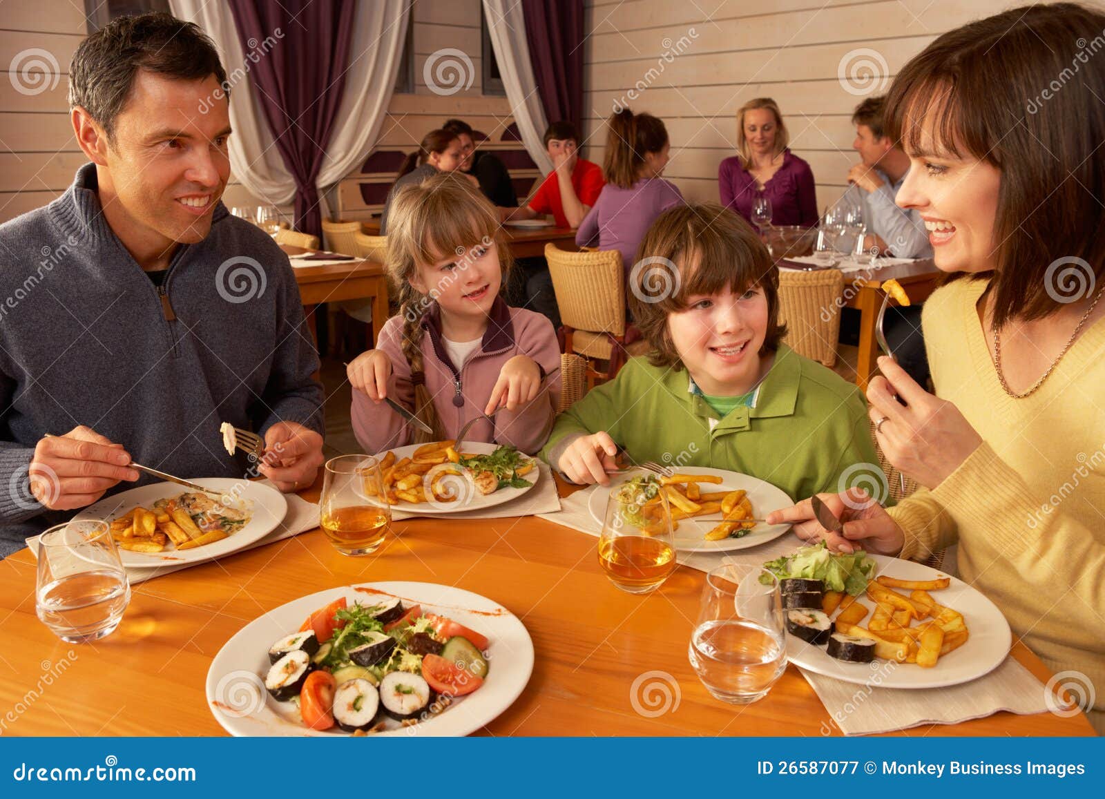 Family Eating Lunch Together In Restaurant Stock Image - Image: 26587077