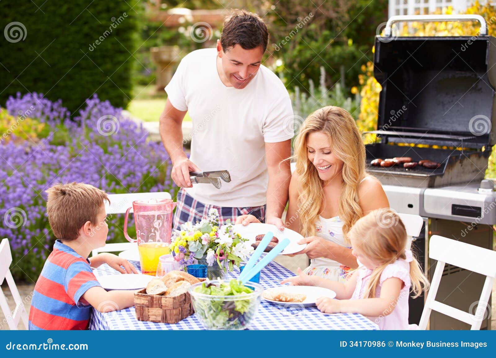 family enjoying outdoor barbeque in garden
