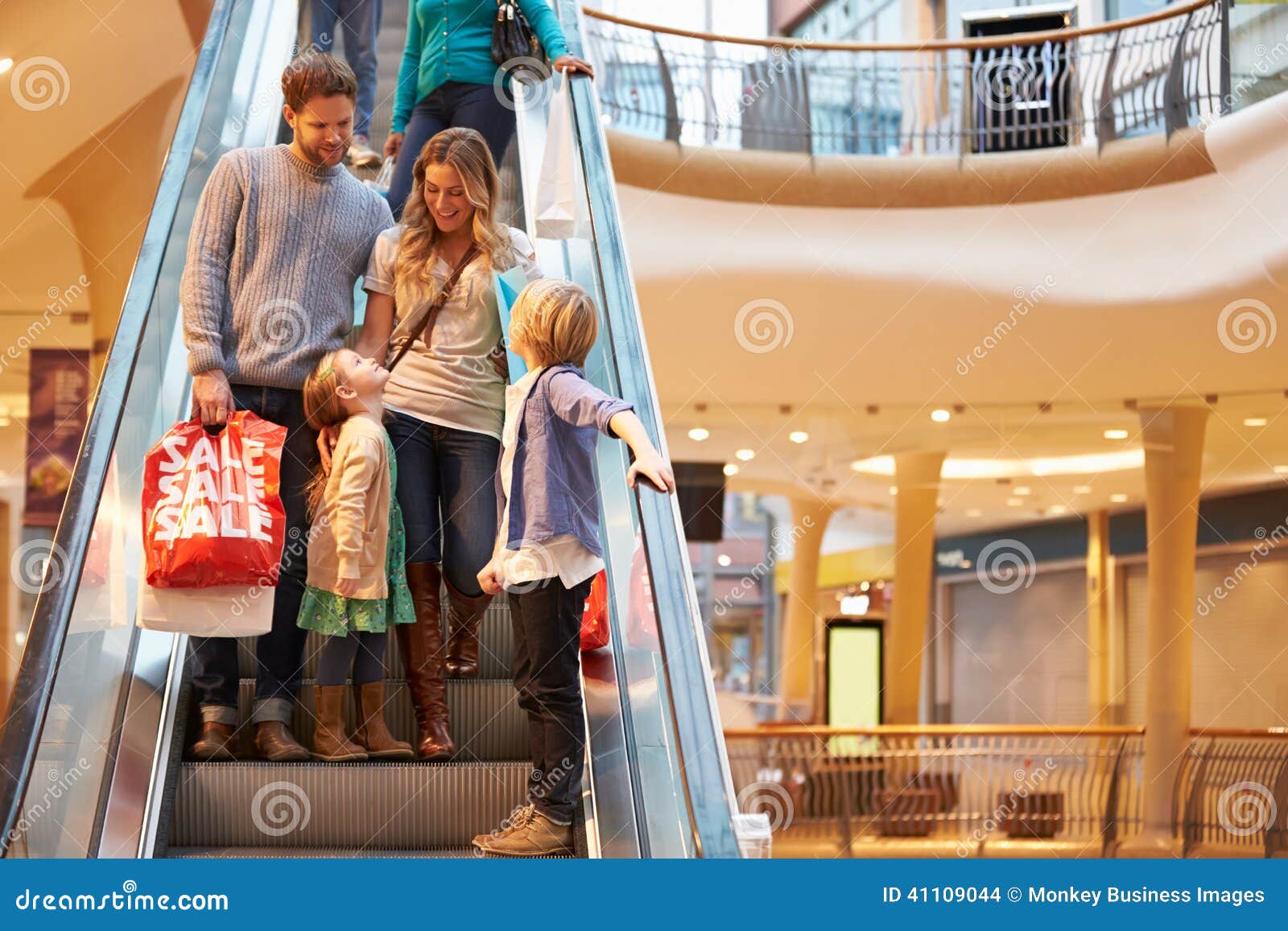 family on escalator in shopping mall together