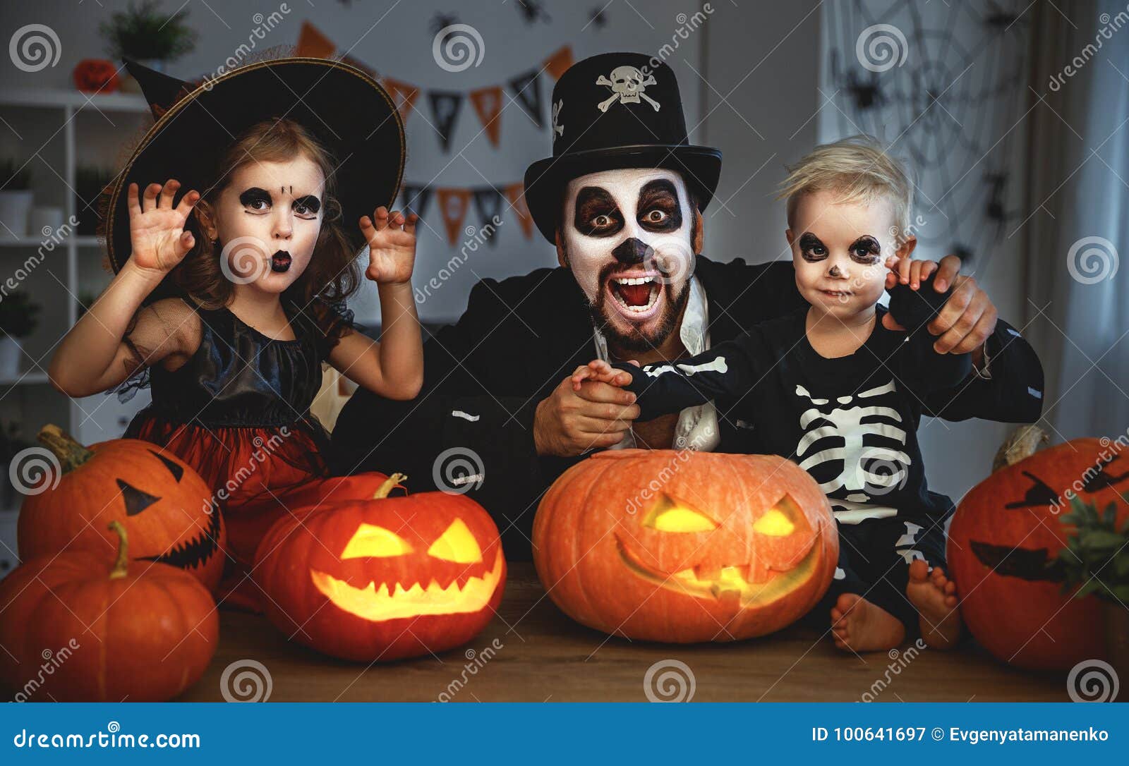 family father and children in costumes and makeup to halloween w