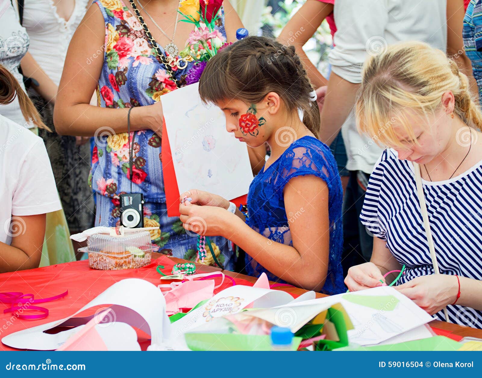 Family festival in Zaporozhye, Ukraine. ZAPOROZHYE, UKRAINE - SEPTEMBER 5, 2015. Participants of bracelets braiding workshop during family festival organized by Charity Fund Child`s Smile for citizens and Donetsk refugees, financed by USAID Project