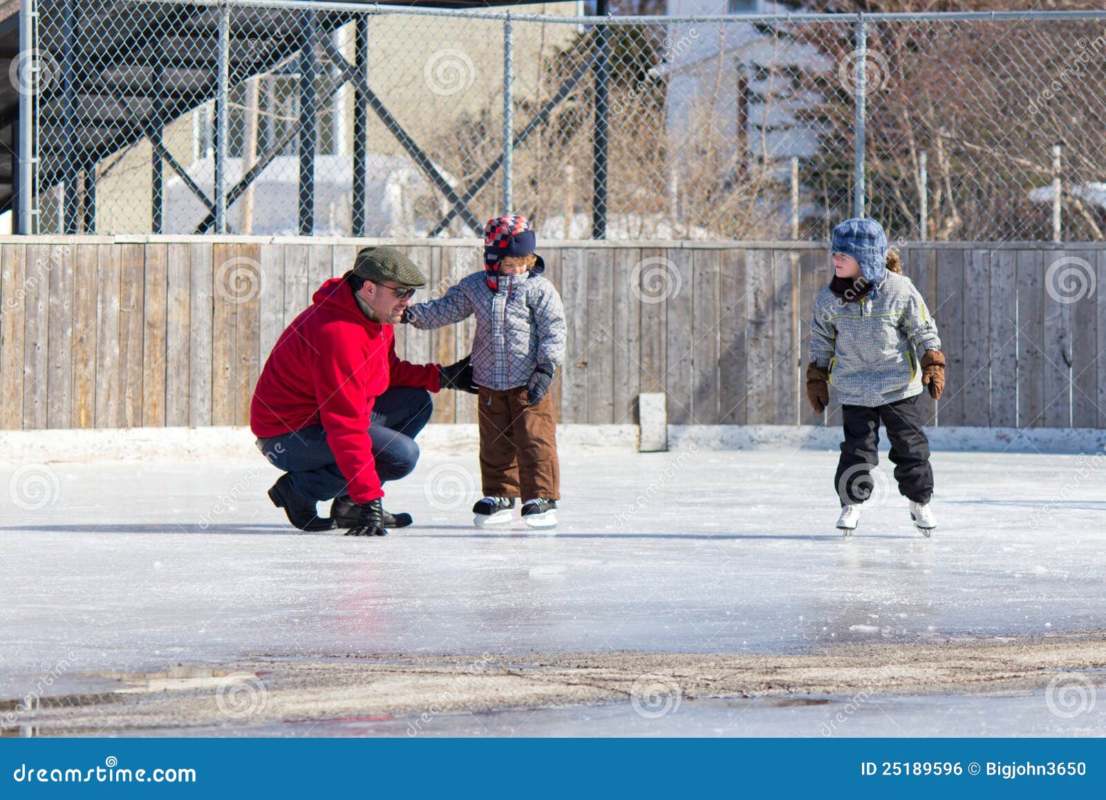 Family having fun at the skating rink. Family having fun at the outdoor skating rink in winter.