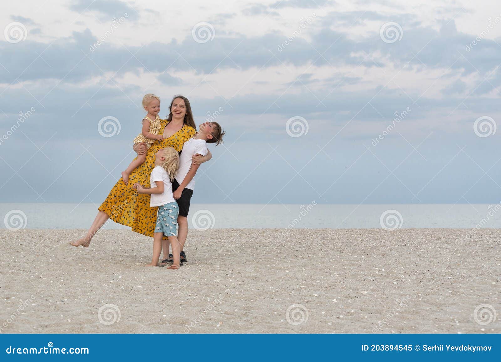 Family Having Fun on Summer Vacation. Mom and Three Children by the Sea