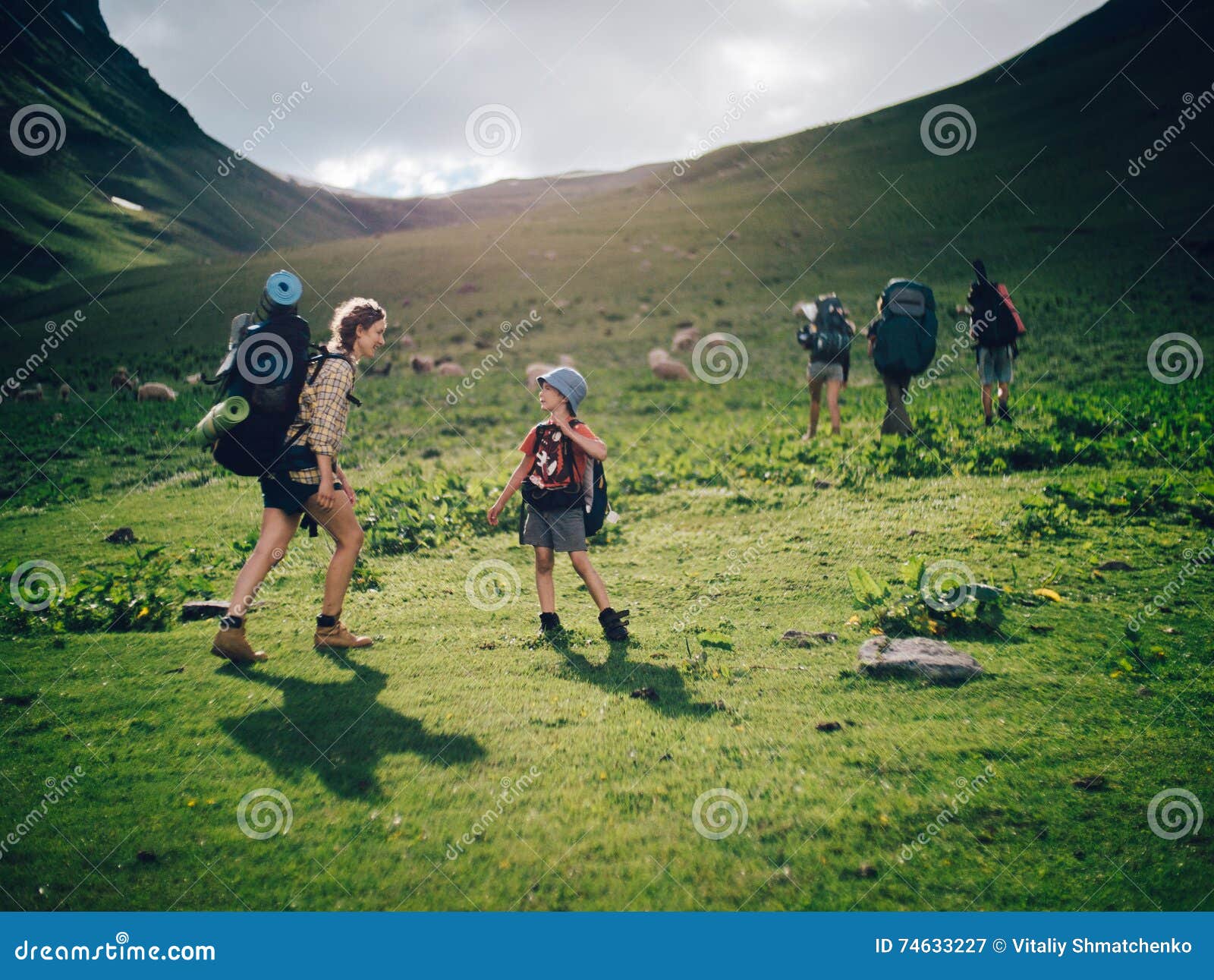family hiking in the mountains. a young happy mother and her son take a hike together in the mountains on a beautiful