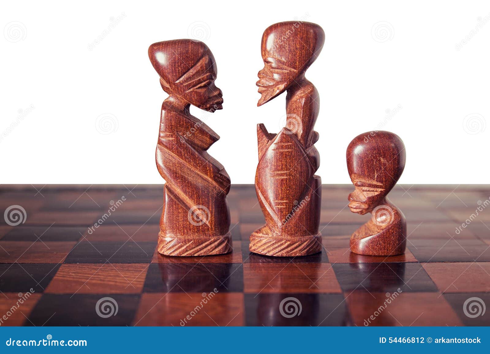 family with husband , wife and a son, represented by three pieces of wooden chess, king, queen and pawn , facing each other.