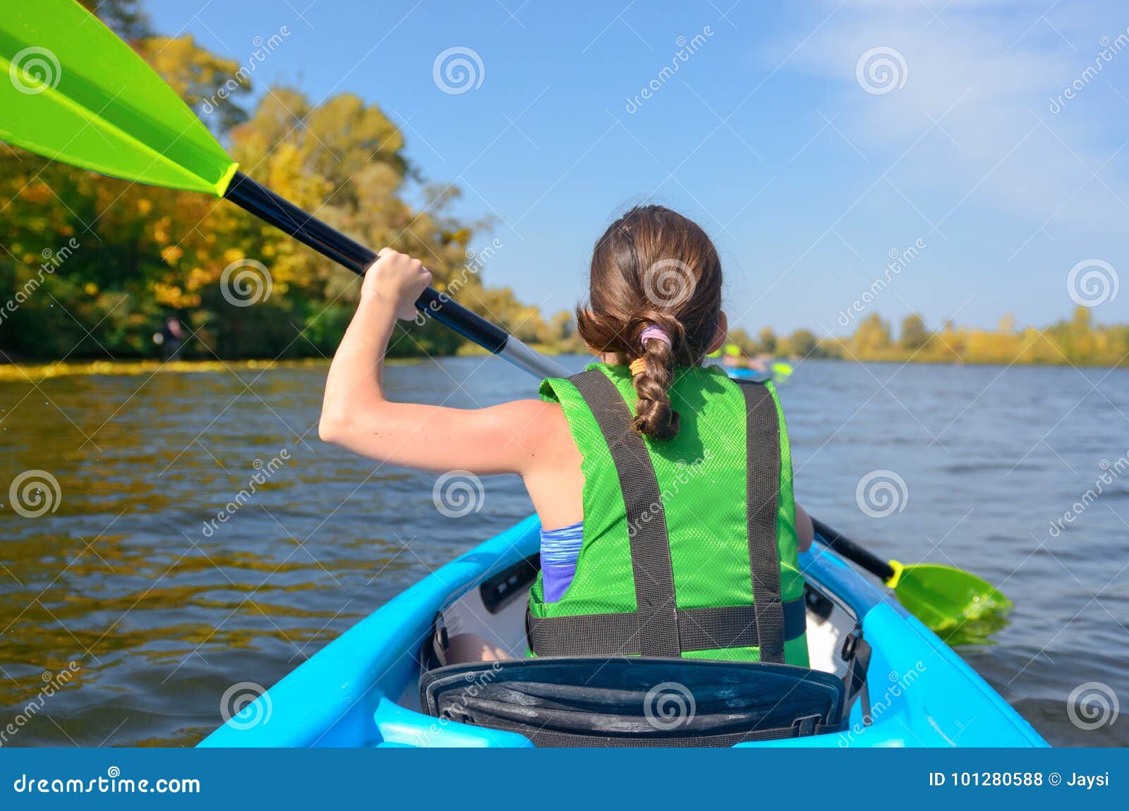 family kayaking, child paddling in kayak on river canoe tour, kid on active autumn weekend and vacation