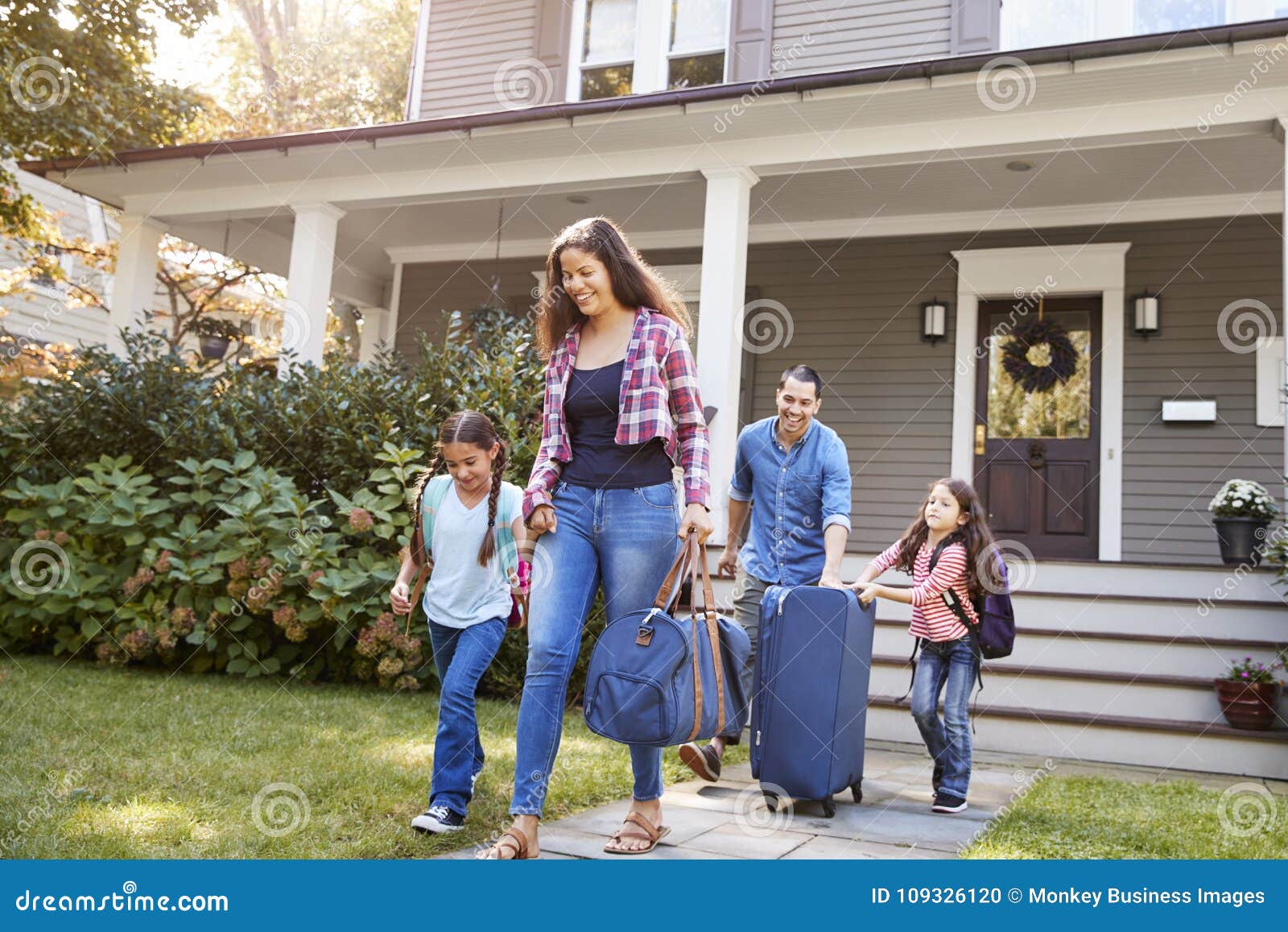 family with luggage leaving house for vacation