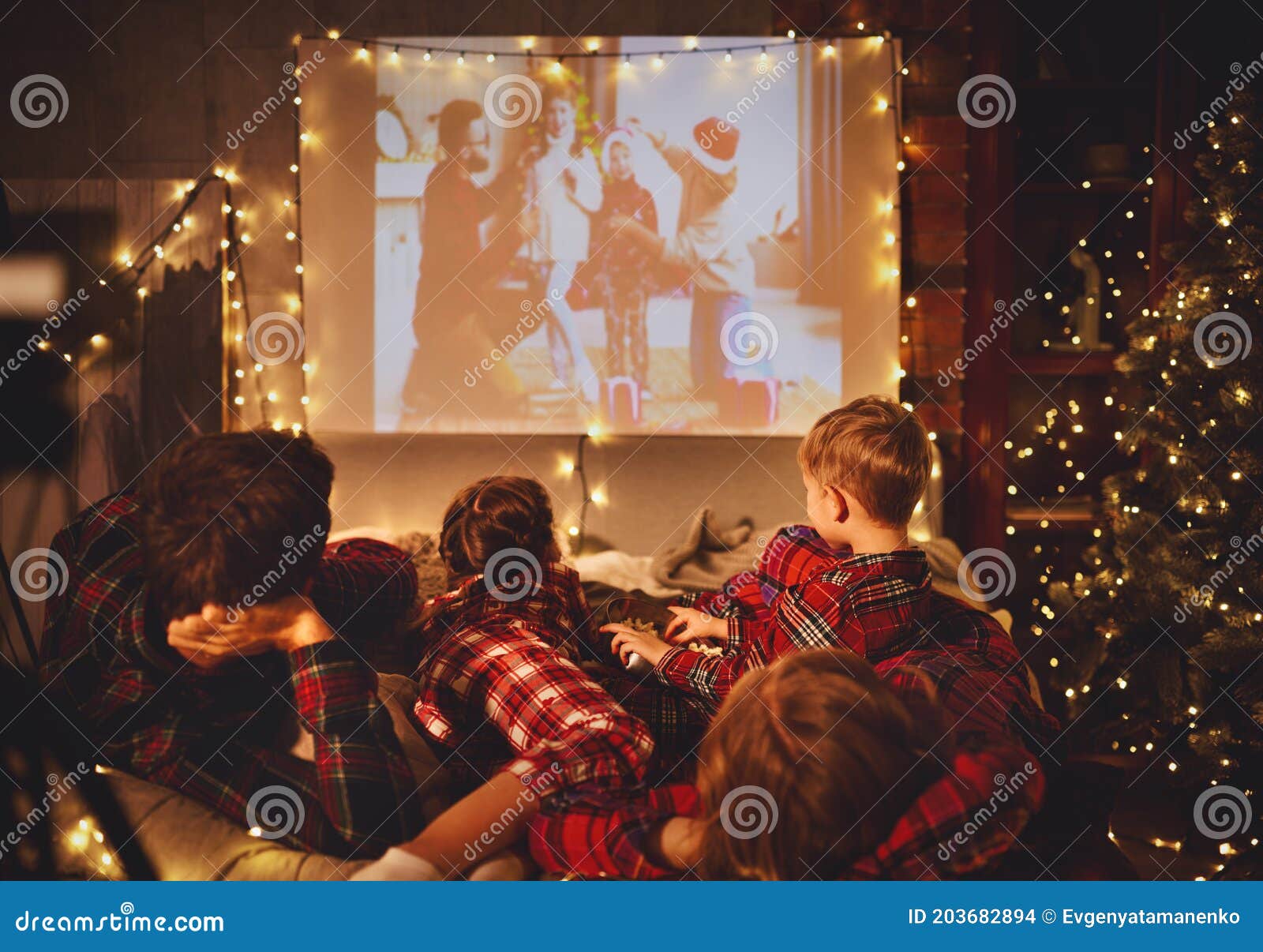 Family Mother Father and Children Watching Projector, TV, Movies with