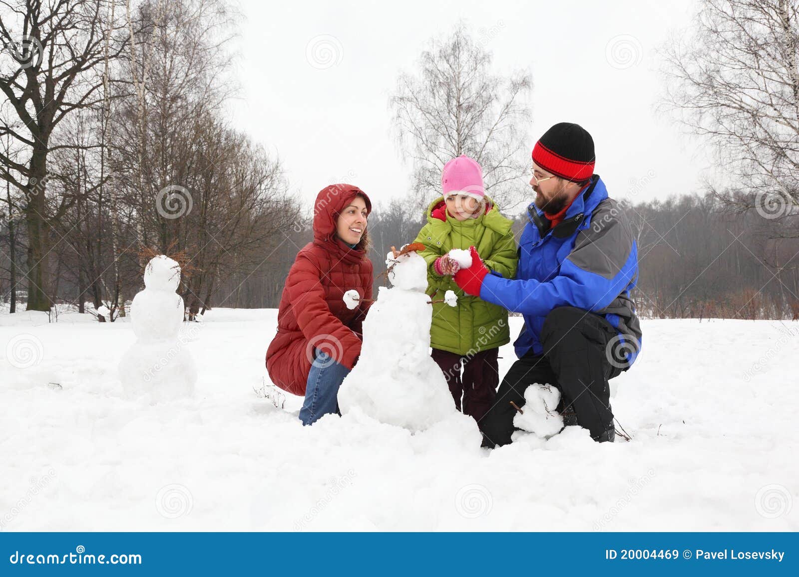 family plays in park in winter