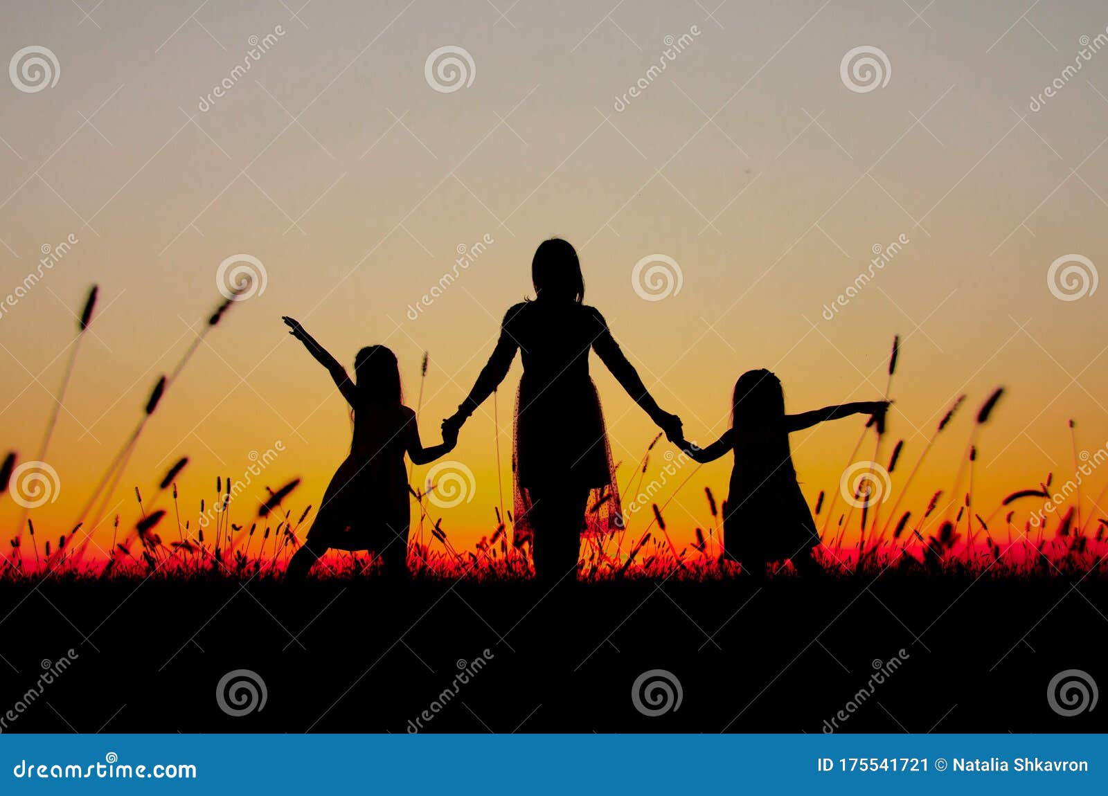 family silhouettes at sunset mom daughters