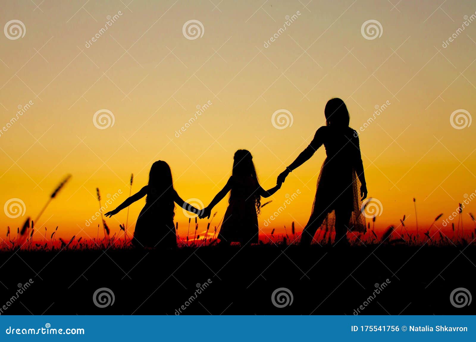 family silhouettes at sunset mom daughters