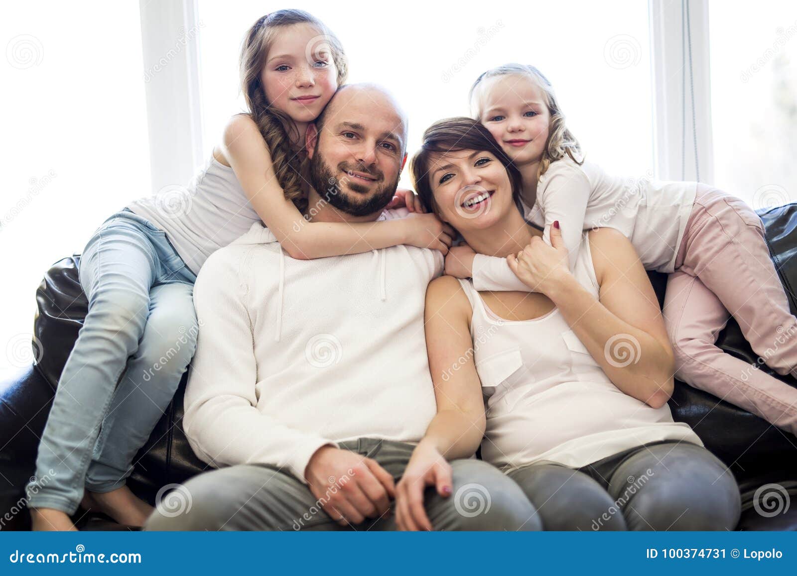 Family Sitting In Living Room Watching Tv