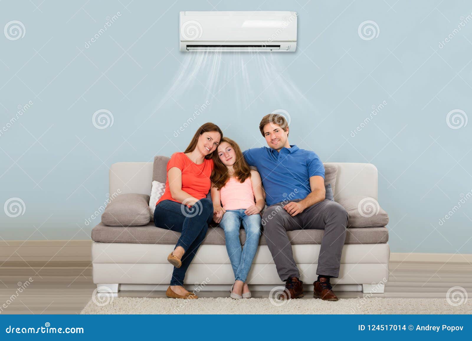 family sitting on sofa under air conditioning