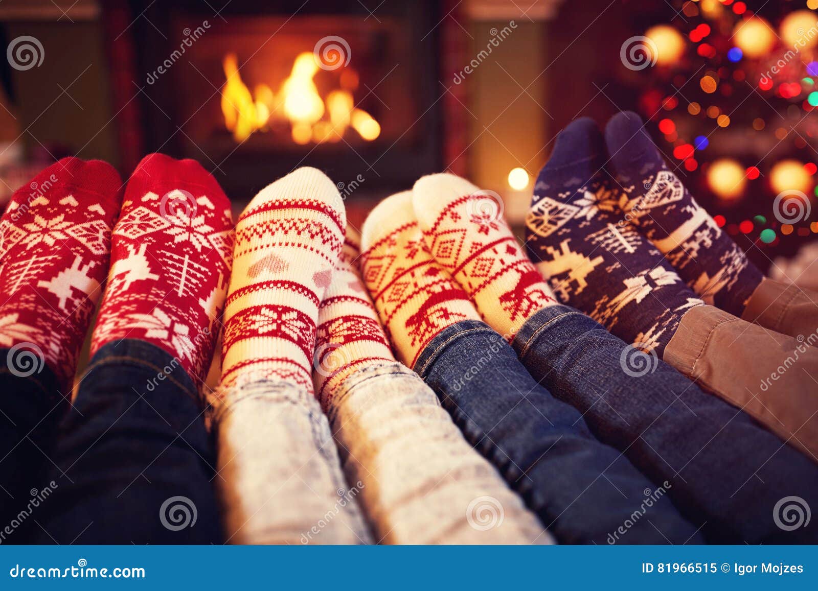family in socks near fireplace in winter
