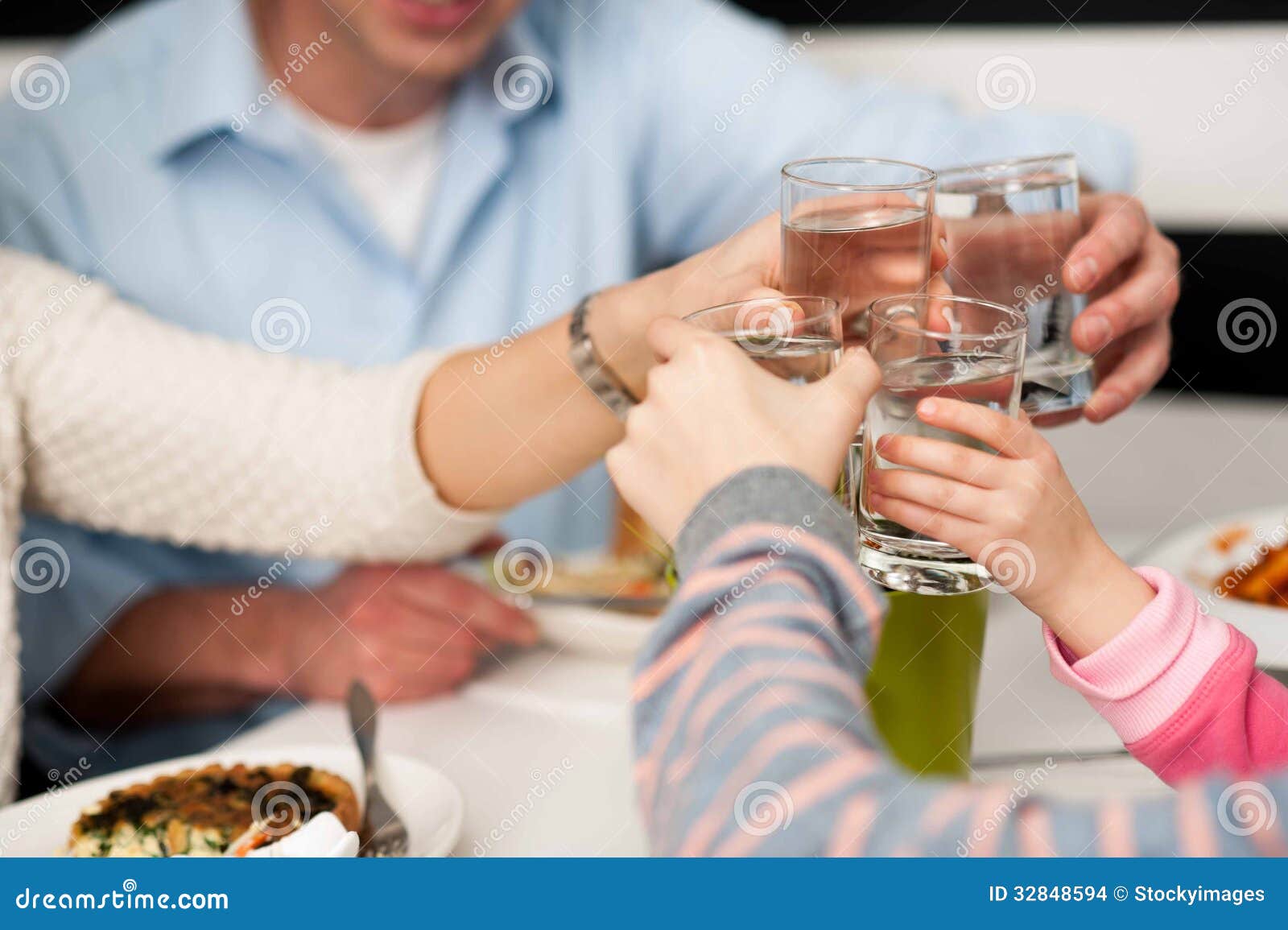 family toasting water glasses in celebration