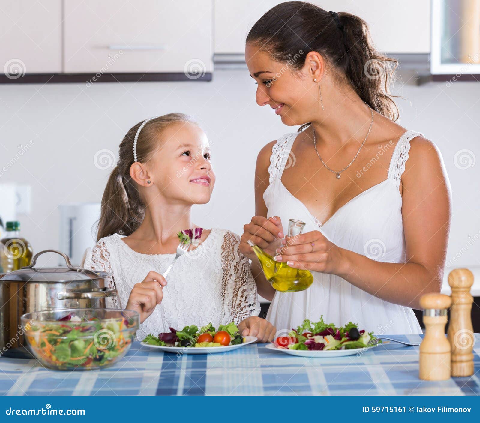 European family of two having healthy lunch with veggies at home