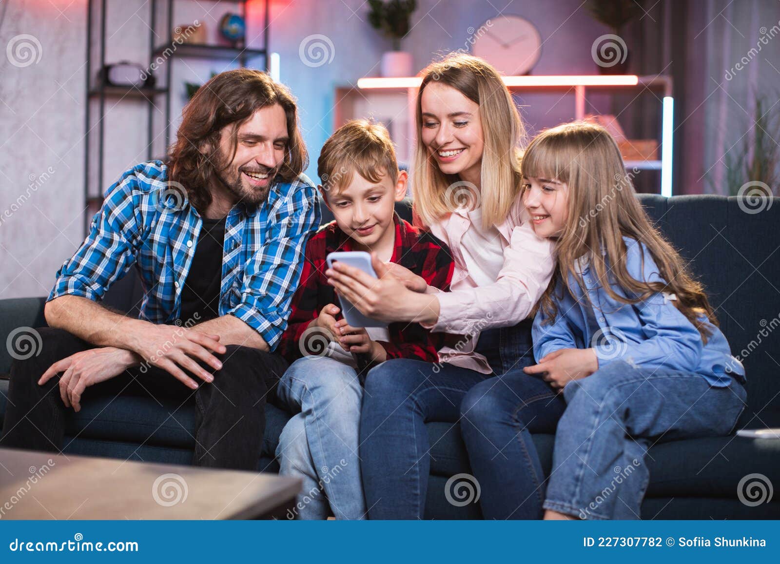 Family Using Cell Phone for Watching Funny Video at Home Stock Photo -  Image of positive, home: 227307782