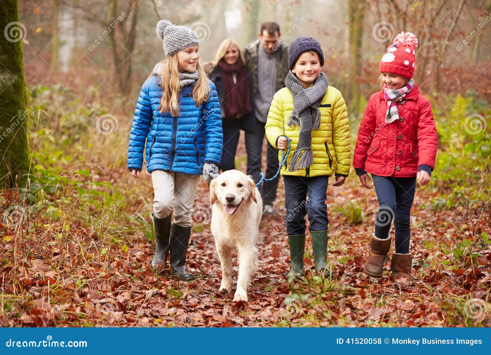 family walking dog through winter woodland
