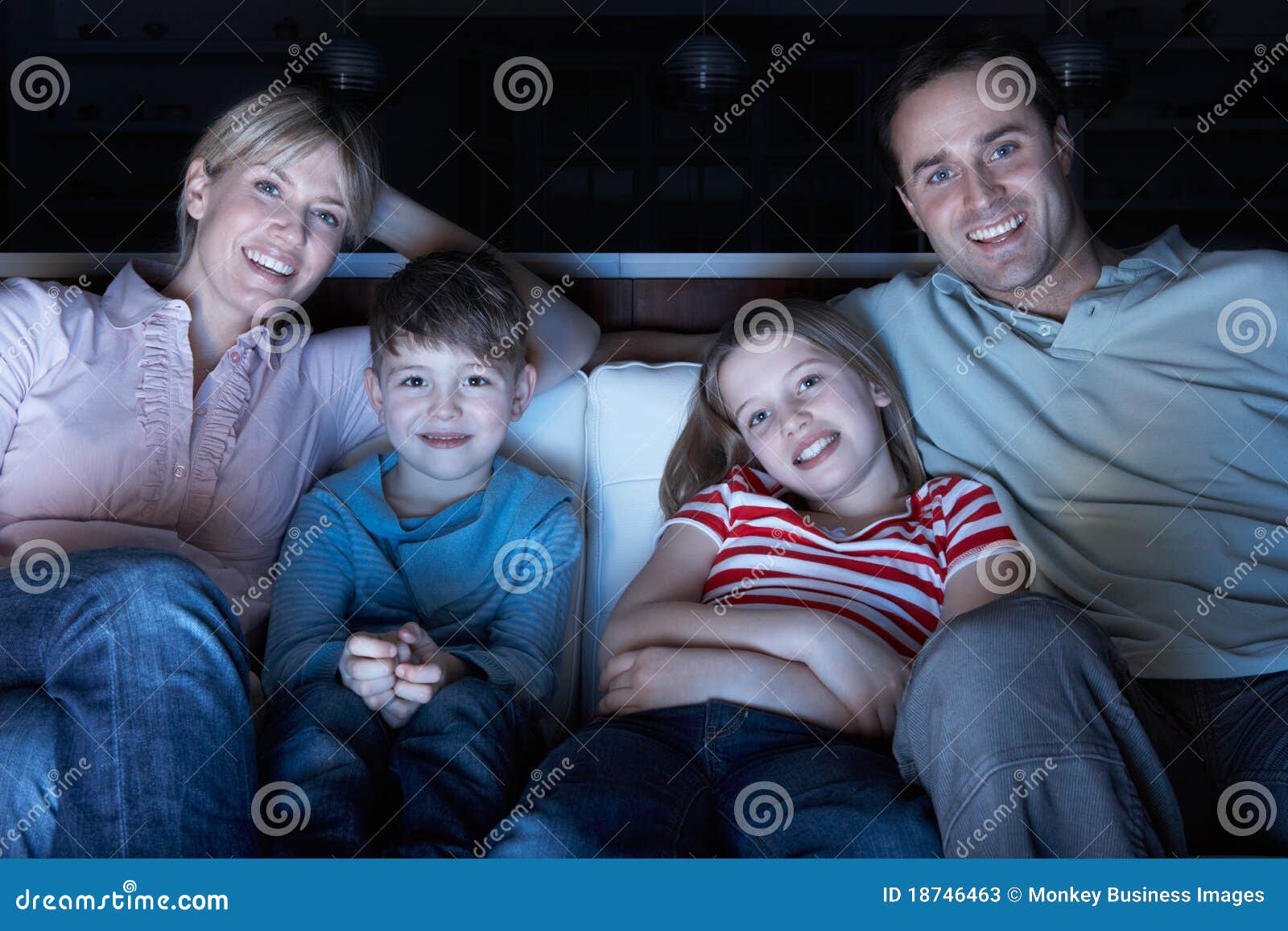 family watching tv on sofa together