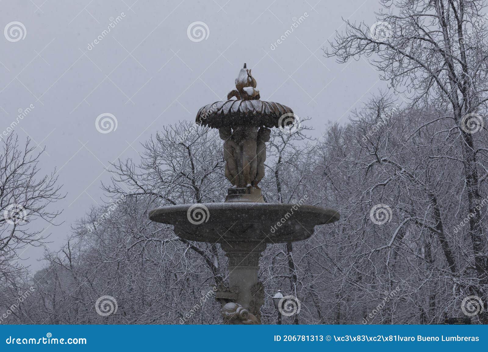 famous alcachofa fountain, in retiro, madrid, in a snowy day