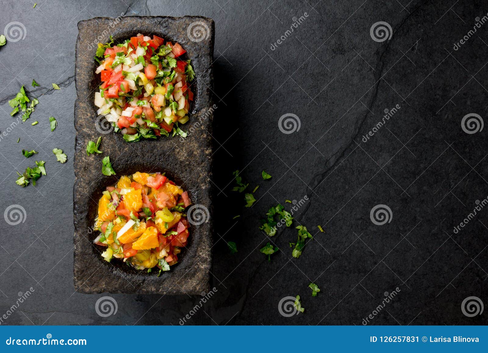 famous mexican sauces salsas - pico de gallo, salsa bandera mexicana in stone mortars on gray slate background