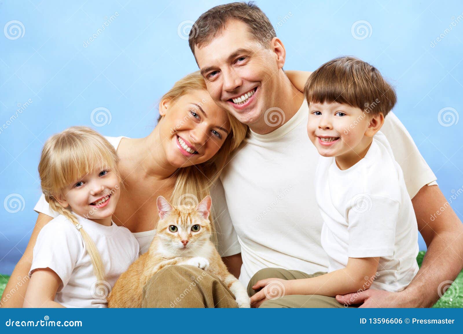 Família com animal de estimação. Retrato dos membros da família afectuosos que olham a câmera no fundo azul