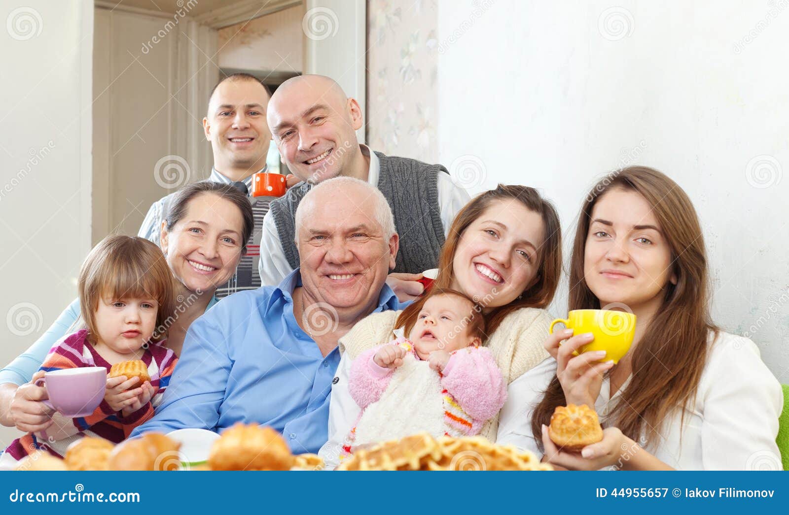 A família multigeneration feliz bebe o chá com cozido