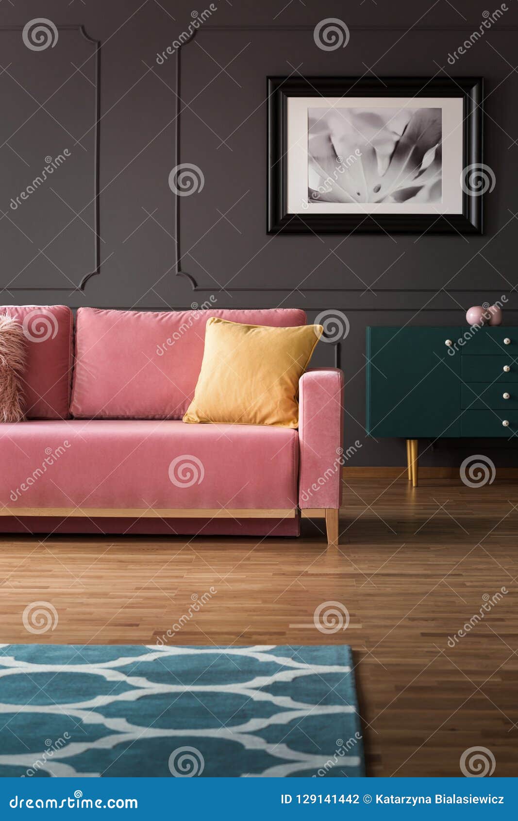 fancy dresser with golden s and a velvet pink sofa on hardwood floor in a vintage living room interior with gray walls. rea