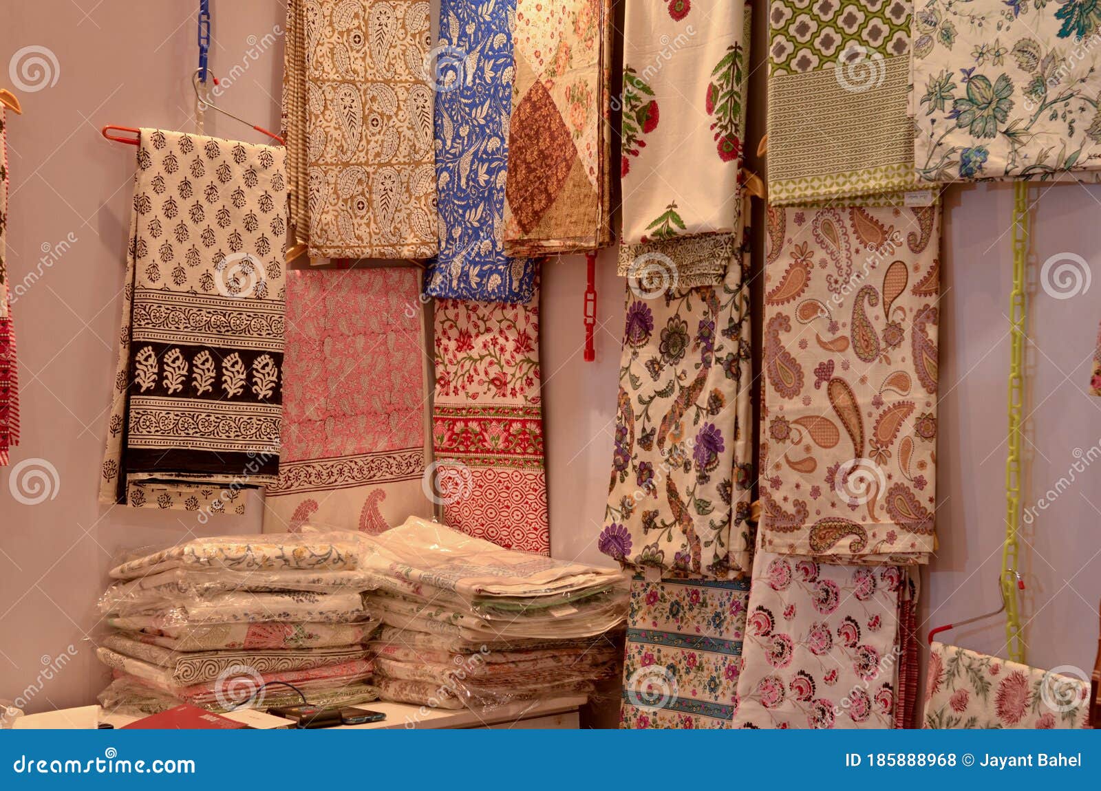Fancy Sarees Unstitched Suits Hanging And Folded On Display In A fancy-sarees-unstitched-suits-hanging-and-folded-on-display-in-a