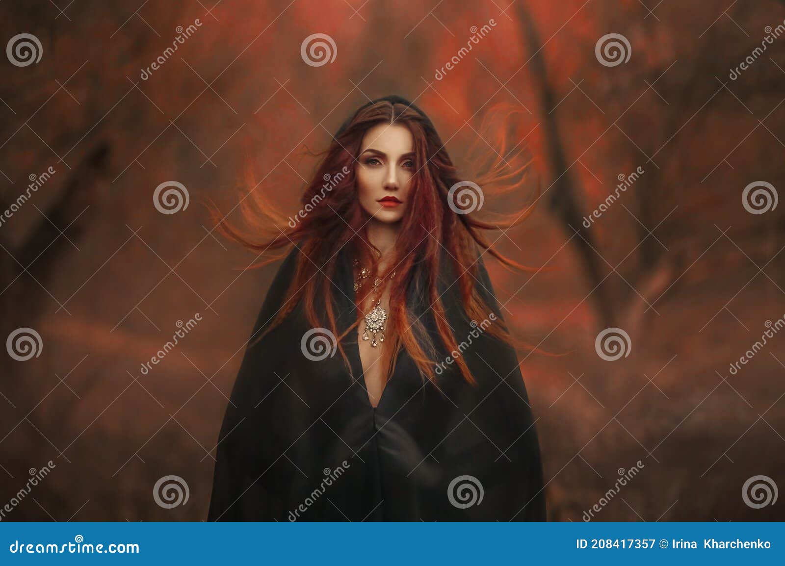 fantasy gothic woman dark witch. red-haired evil girl demon in black dress cape hood. long hair flutters fly in wind