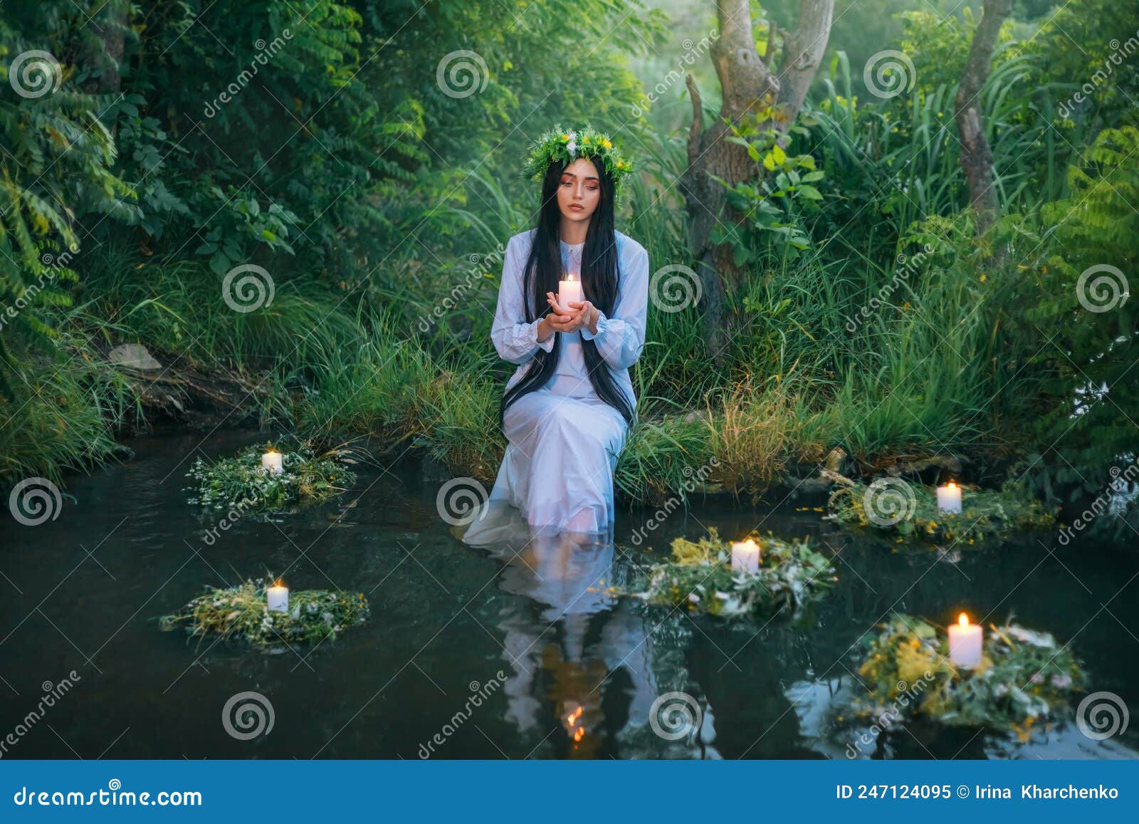 fantasy pagan witch slavic woman holding candle in hand. divination summer tradition. girl mermaid nymph sits on banks
