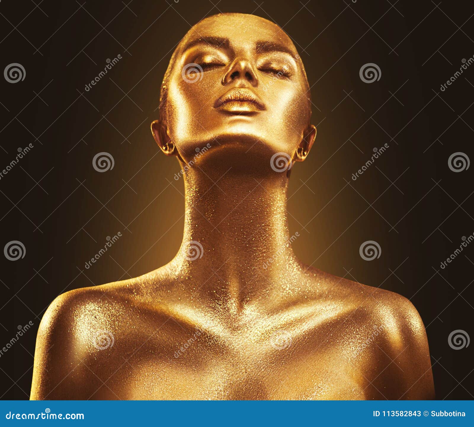 Body Art. Woman painting Body with Paint Brush in Golden Color