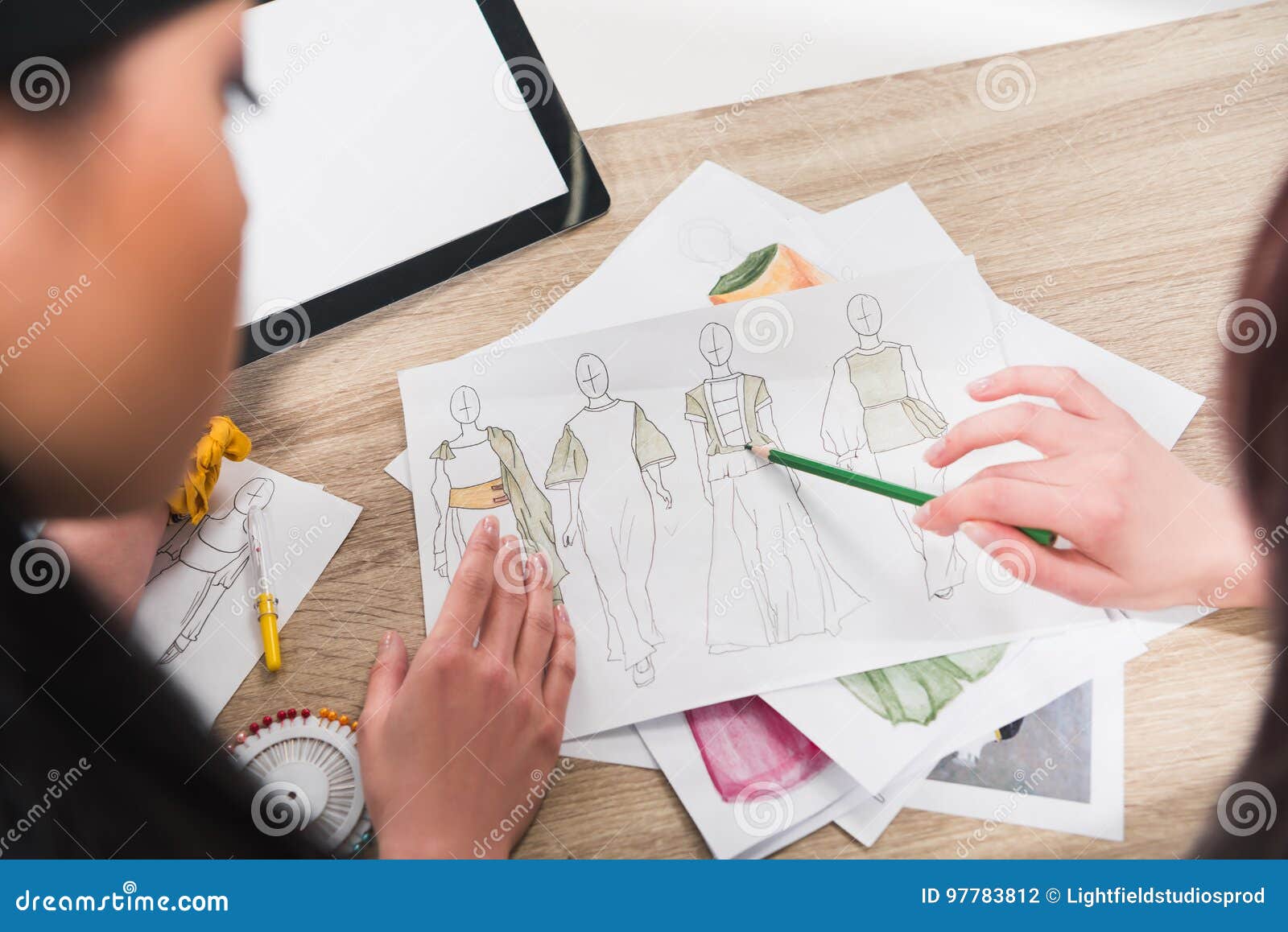 Fashion Designers Working with Blueprints of Models at Table Stock