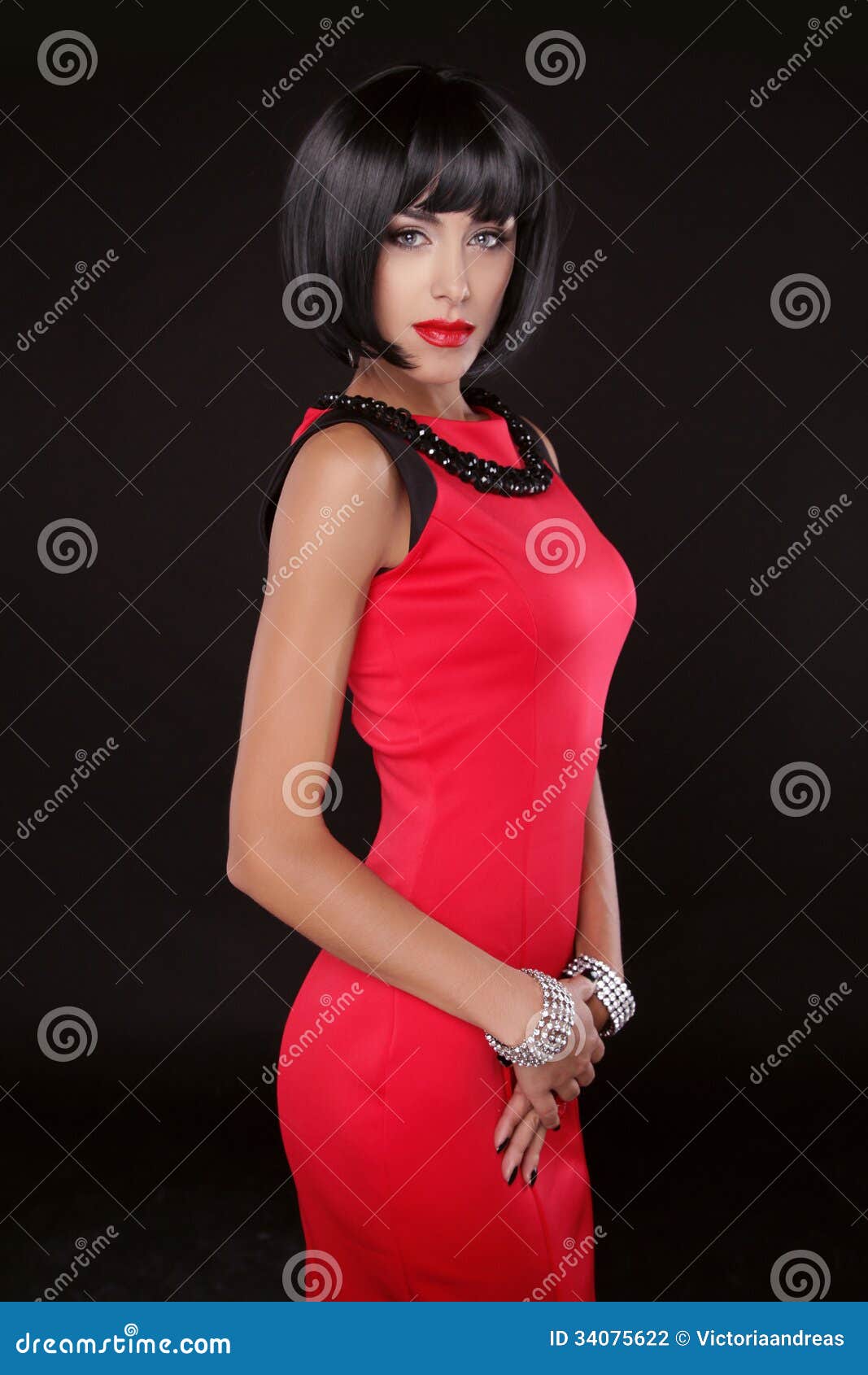 fashion elegant woman in red dress. brunette lady with black short hair. vogue style. model posing  on black background